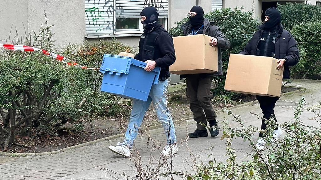 Ermittler gehen mit Kisten und Kartons in das Wohnhaus der früheren RAF-Terroristin Daniela Klette. Foto: Paul Zinken/dpa