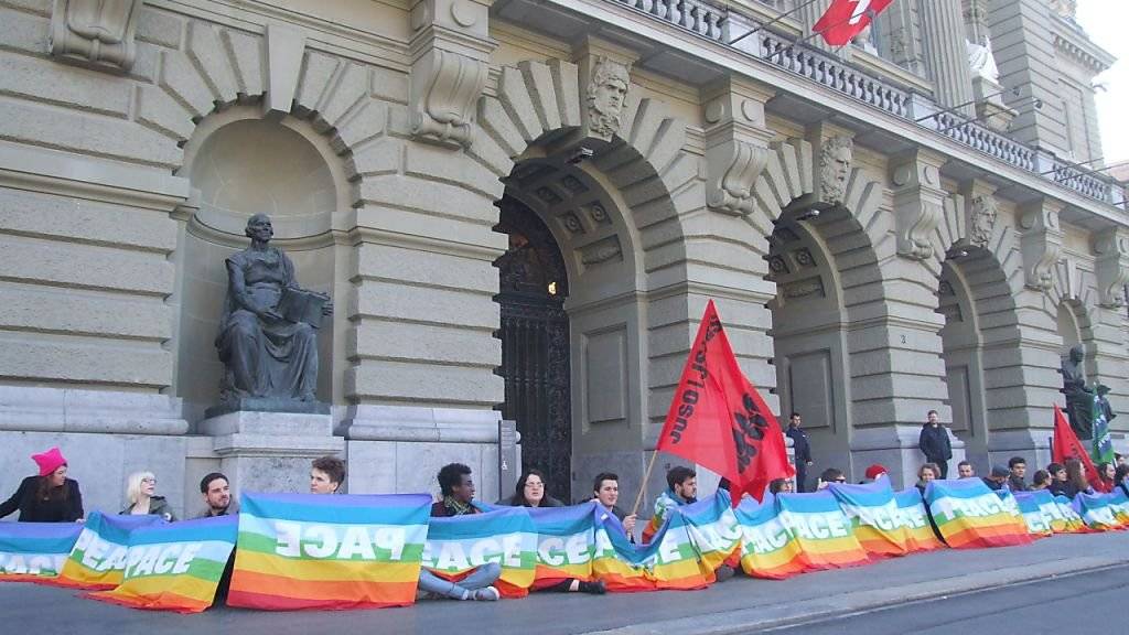 Aktivistinnen und Aktivisten bildeten eine Menschenkette vor dem Bundeshaus und forderten damit das Parlament auf, sich für eine konsequente Friedenspolitik einzusetzen.