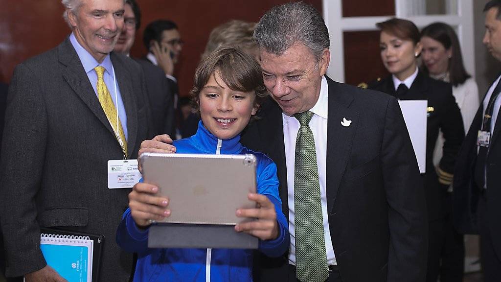 Kolumbiens Präsident Juan Manuel Santos stellt sich einem Jungen für ein Selfie zur Verfügung (Archiv)
