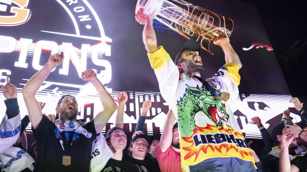 Captain Julien Sprunger vom HC Fribourg-Gottéron präsentiert den tausenden Fans vor dem Stadion am frühen Freitagmorgen den Meisterpokal.