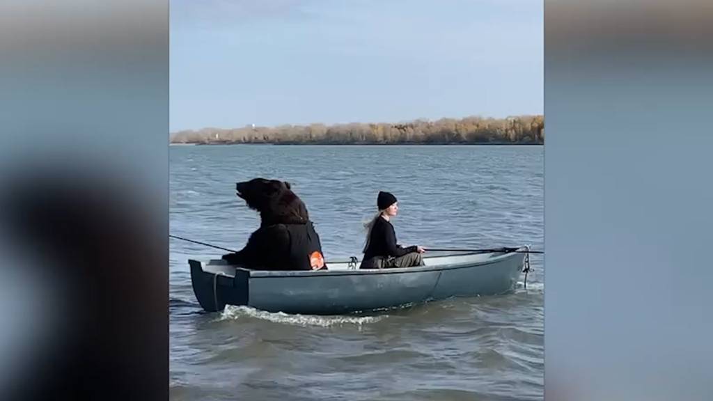 Diese junge Frau sitzt mit einem riesigen Bär im Boot