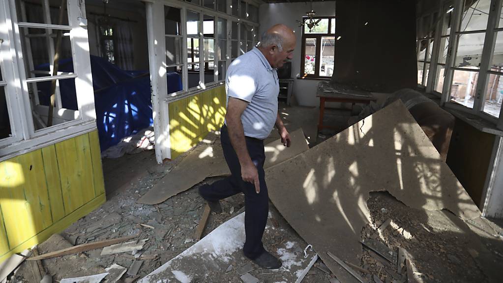 Nach Angriffen armenischer Truppen inspiziert ein Mann sein beschädigtes Haus im aserbaidschanischen Tartar.