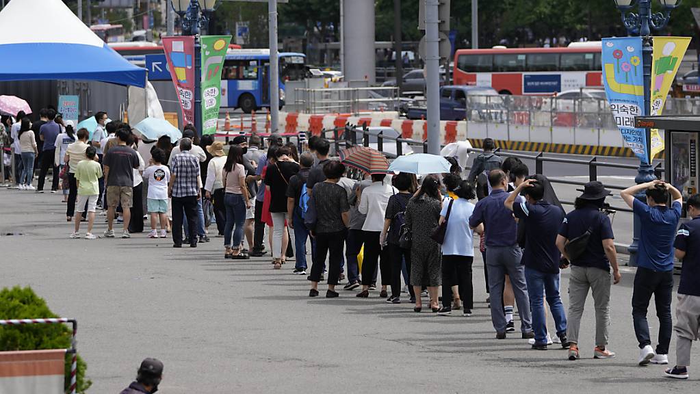 Menschen stehen Schlange vor einem Corona-Testzentrum. Südkorea hat den zweithöchsten Tageswert registrierter Corona-Neuinfektionen seit Beginn der Pandemie verzeichnet. Foto: Lee Jin-Man/AP/dpa Foto: Lee Jin-Man/AP/dpa