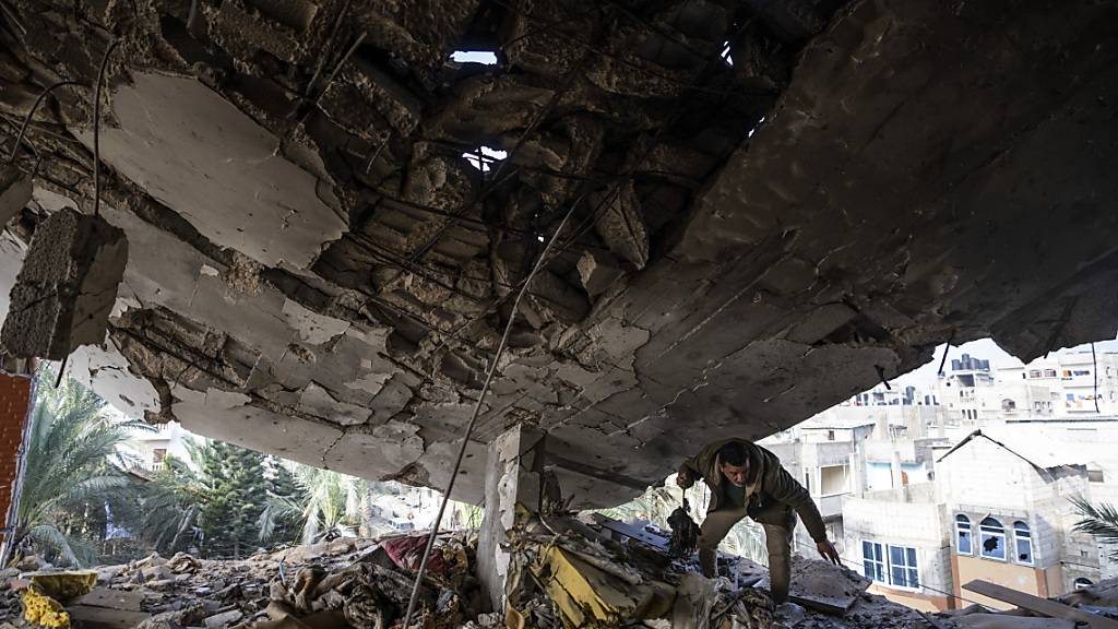 Ein Palästinenser rettet seine Habseligkeiten nach einem israelischen Angriff. Foto: Fatima Shbair/AP/dpa