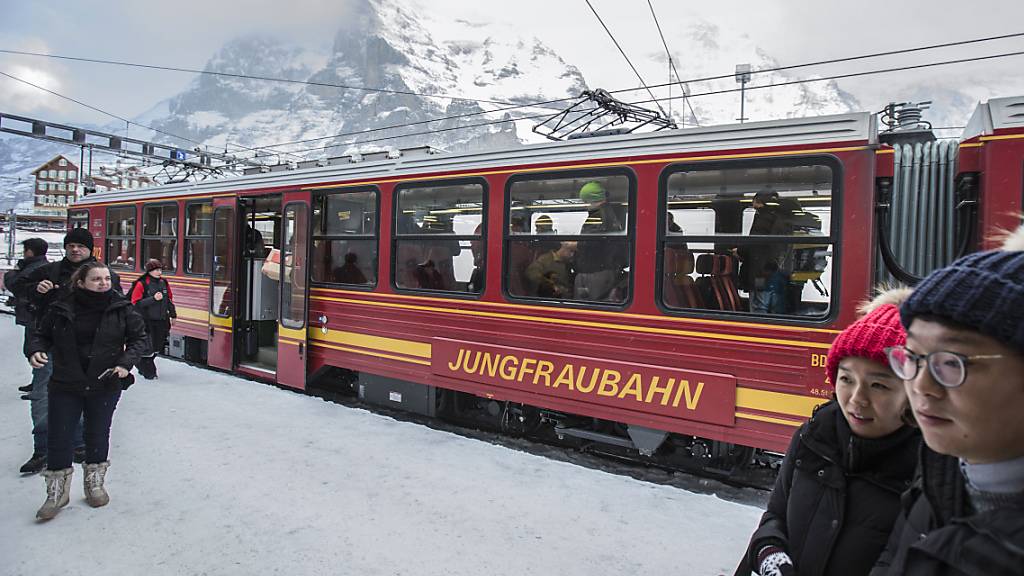 Asiatische Touristen stehen vor einem Zug der Jungfraubahn (Archivbild).