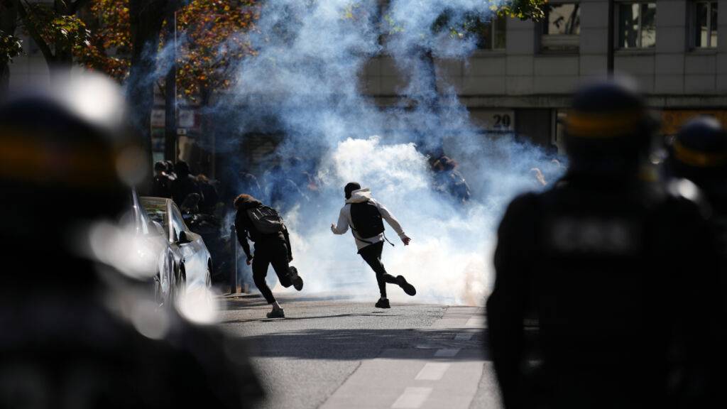 Schüler rennen durch Tränengas, während sie bei einer Demonstration gegen unterfinanzierte Schulen mit Polizisten zusammenstoßen. Seit Tagen protestieren Schülerinnen und Schüler an den Oberschulen. Foto: Aurelien Morissard/AP/dpa