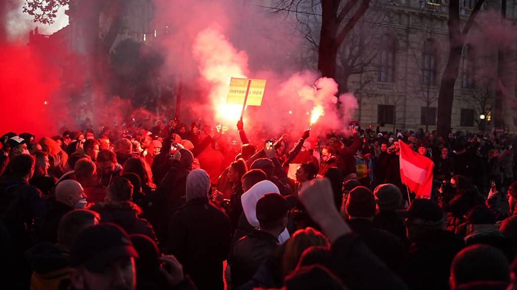 Menschen nehmen an einer Demonstration gegen die Coronavirus-Beschränkungen des Landes teil. Laut Polizei nahmen in Wien rund 35 000 Menschen an Demonstrationen gegen den Lockdown und die Impfpflicht teil. «Die Stimmung ist aufgeheizt», sagte ein Polizeisprecher. Foto: Florian Schroetter/AP/dpa