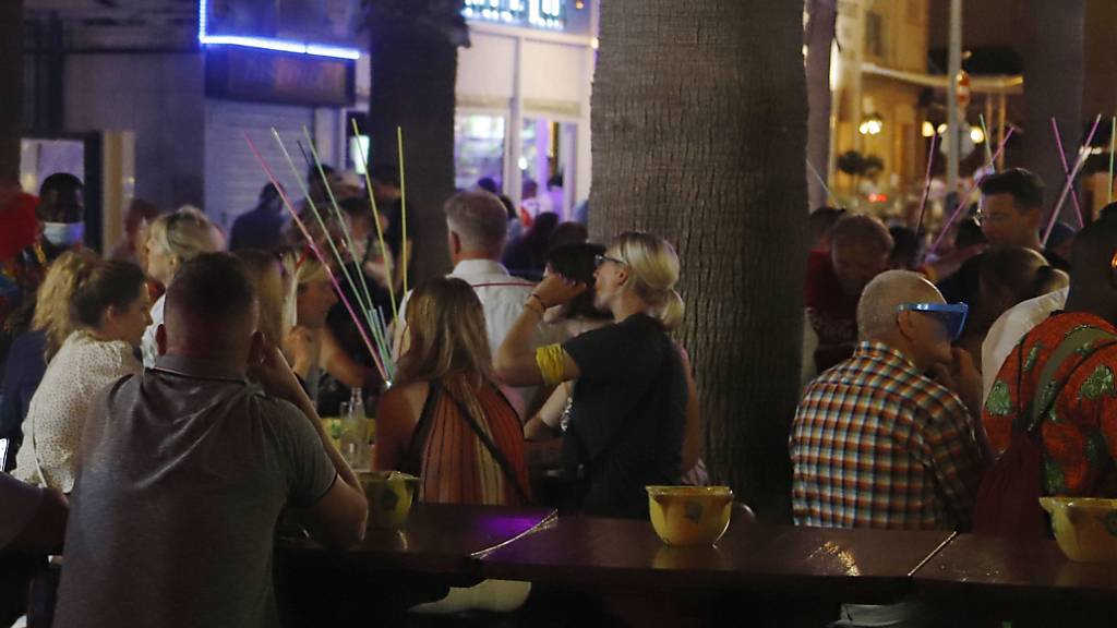 ARCHIV - Touristen sitzen dicht an dicht auf einer Terrasse eines Lokals auf der so genannten Bierstraße. Foto: Clara Margais/dpa