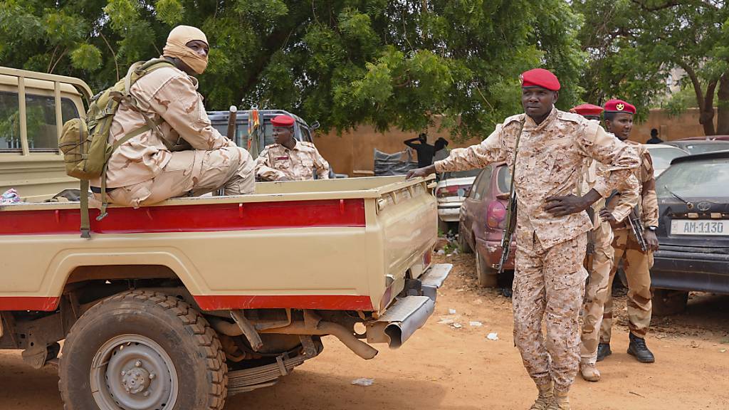 Nigerianische Nationalgardisten sitzen vor dem Zollamt. Foto: Sam Mednick/AP/dpa