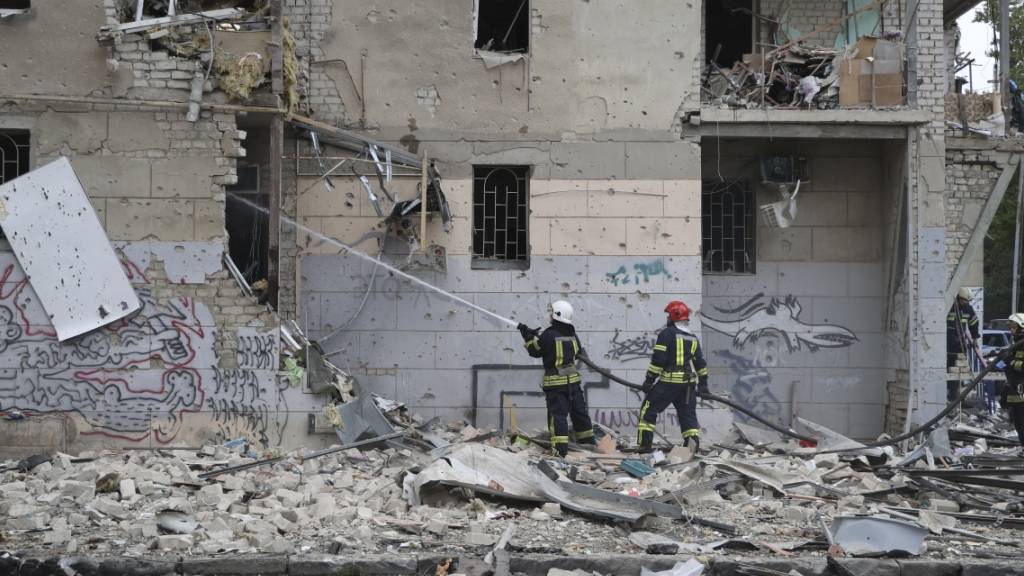 Ukrainische Feuerwehrleute löschen ein Feuer nach einem Luftangriff, der ein Wohnhaus beschädigt hat. Foto: Alex Babenko/AP/dpa