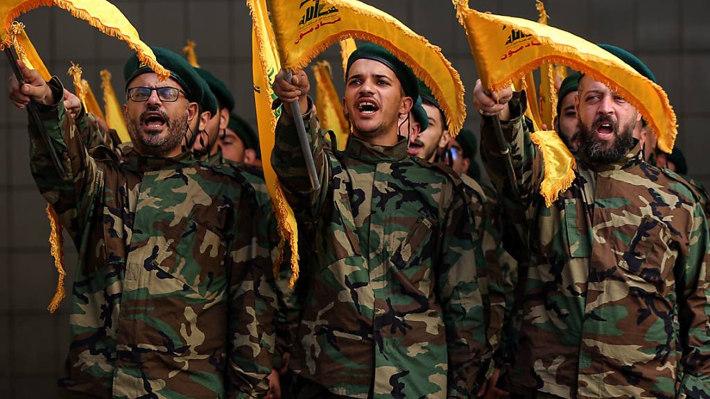 Hisbollah-Kämpfer skandieren Parolen während des Trauerzugs für einen ihrer Kameraden, der bei Zusammenstößen mit israelischen Truppen im Südlibanon getötet wurde. Die israelische Luftwaffe hat nach Angriffen aus dem Libanon Ziele in dem nördlichen Nachbarland beschossen. Foto: Marwan Naamani/dpa
