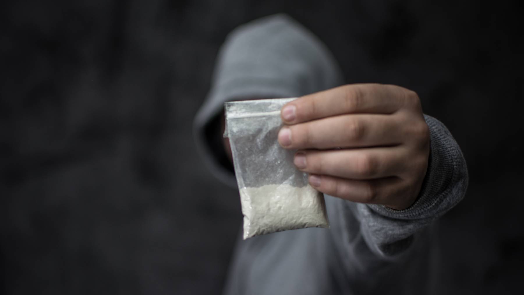 Mann mit Kokainpulver in Plastiktüte // Koks Drogen Dealer Symbolbild