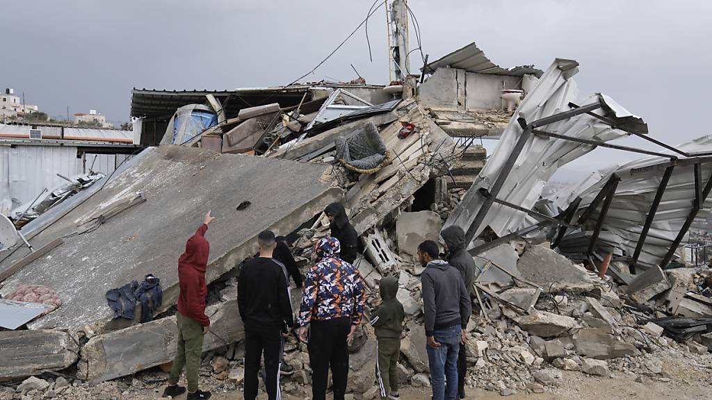 Palästinenser begutachten die Trümmer nach einer israelischen Razzia in der Stadt. Foto: Majdi Mohammed/AP