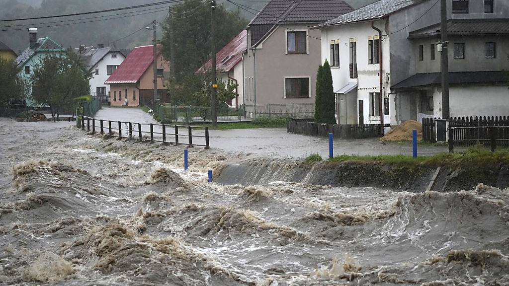 ARCHIV - Der vom Hochwasser aufgewühlte Fluss Bela rauscht in Tschechien an Häusern vorbei. Foto: Petr David Josek/AP/dpa