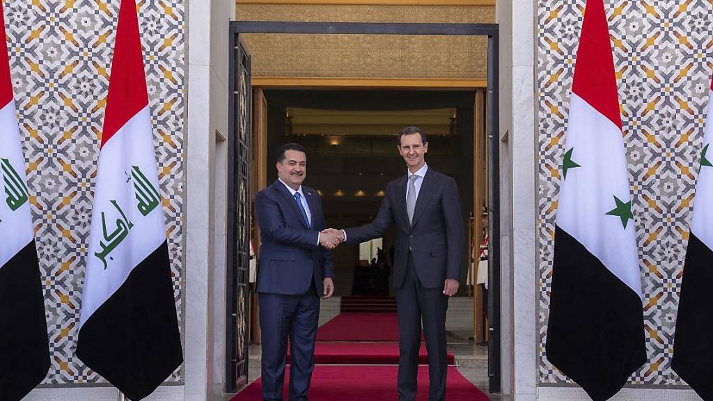 HANDOUT - Der syrische Präsident Baschar al-Assad (r) begrüßt den irakischen Premierminister Mohammed Shia' al-Sudani in Damaskus. Foto: Uncredited/SANA/AP/dpa - ACHTUNG: Nur zur redaktionellen Verwendung und nur mit vollständiger Nennung des vorstehenden Credits