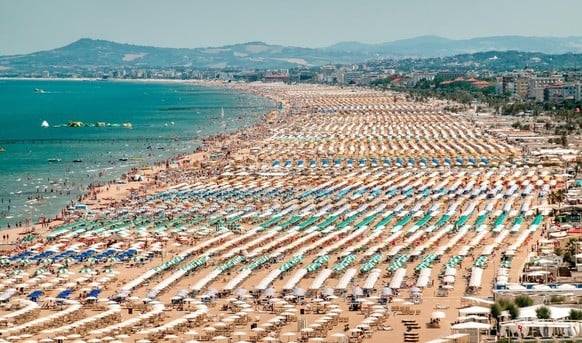 Am Strand von Rimini steht Liegestuhl an Liegestuhl.
