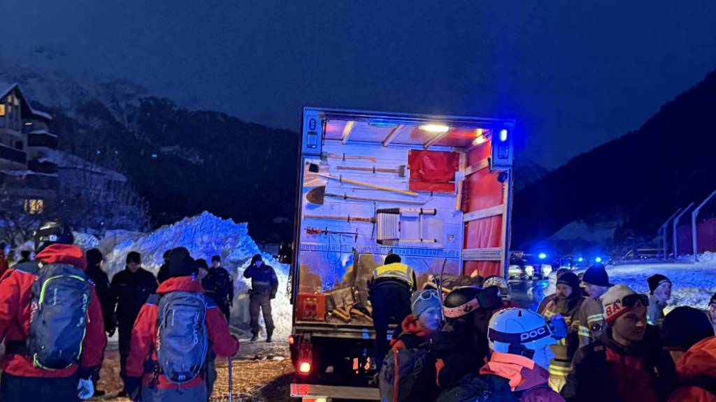 Einsatzkräfte und Helfer stehen bei einem LKW in St. Anton am Arlberg. Foto: Bernhard Flatscher/extremwetter.tv/dpa