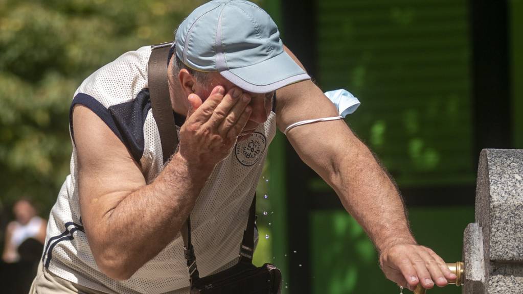 Ein Mann versucht, sich in einem Brunnen im Retiro-Park in Madrid abzukühlen. Foto: Andrea Comas/AP/dpa