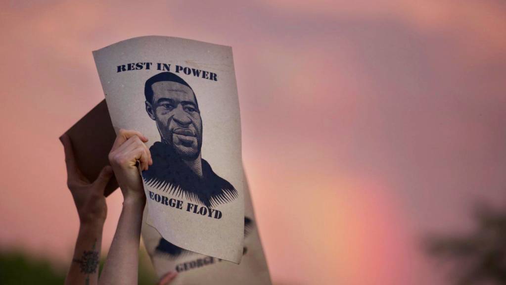 Demonstranten halten während eines Protestes-Zettel mit dem Porträt von George Floyd, des in Minneapolis nach einem brutalen Polizeieinsatz gestorbenen Mannes afroamerikanischer Abstammung, in die Höhe.