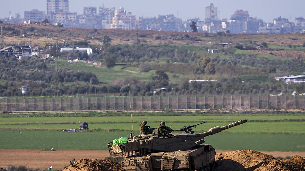 Ein israelischer Panzer steht an der Grenze zum Gazastreifen, vom Süden Israels aus gesehen. Foto: Ariel Schalit/AP/dpa