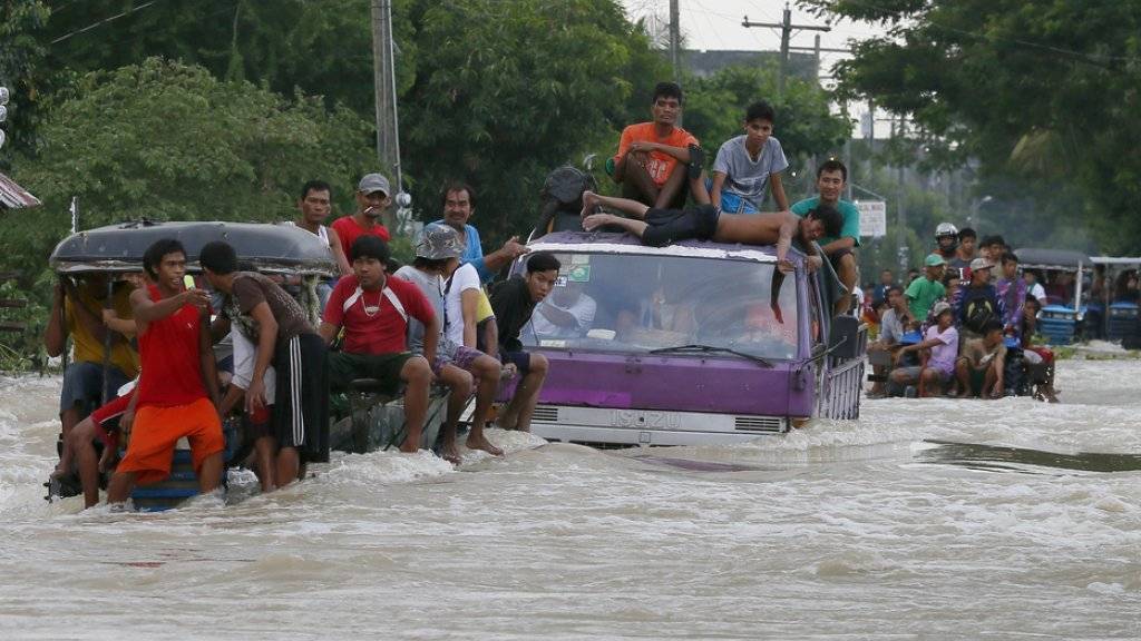 Fahrzeuge kämpfen sich auf den Philippinen durch gewaltige Wassermassen. Der Taifun «Koppu» hat für enorme Schäden im Inselstaat gesorgt