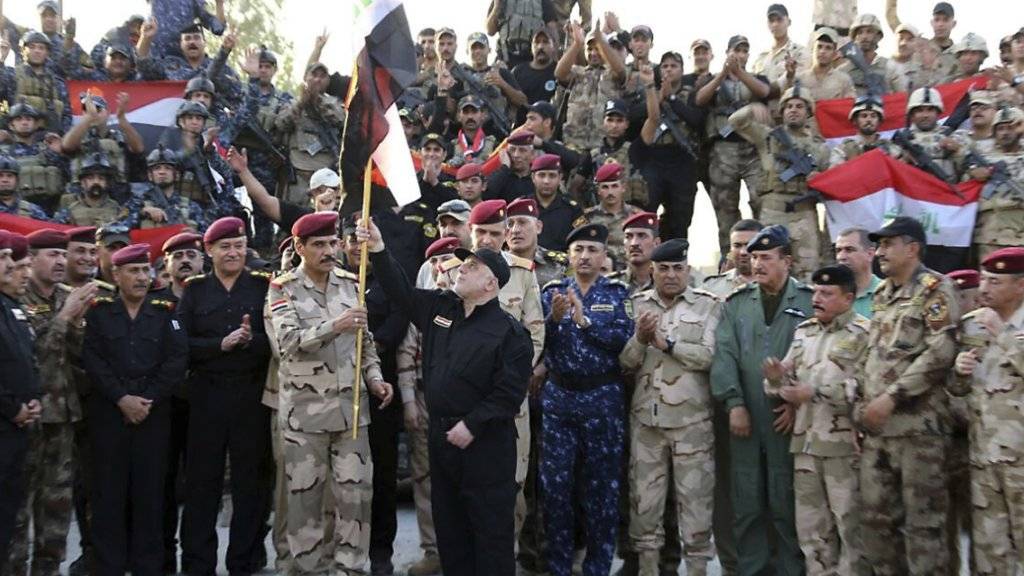 Nach monatelangen Kämpfen hat Iraks Regierungschef Haidar al-Abadi (in schwarzer Kleidung, Bildmitte) die bisherige IS-Hochburg Mossul offiziell für befreit erklärt.
