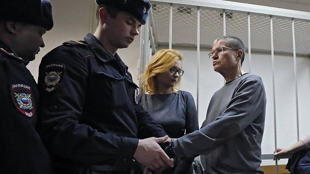 Ein Polizist legt dem Alexej Uljukajew im Gericht Handschellen an - der russische Ex-Wirtschaftsminister wurde wegen der Annahme von Schmiergeld verurteilt.