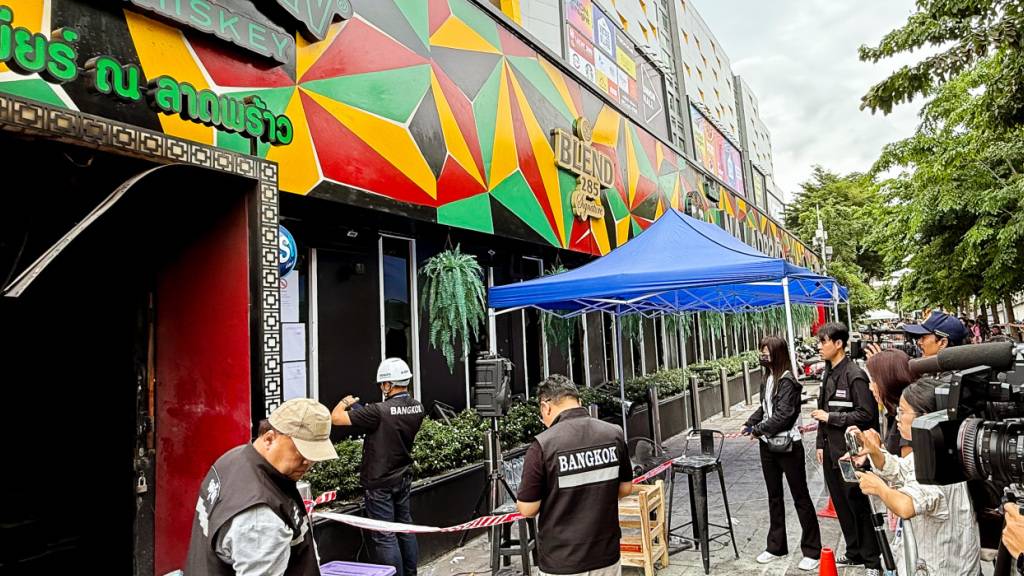Kriminalermittler und Medienvertreter arbeiten nach einem Brand vor dem Lokal Rong Beer Na Ladprao. Foto: Carola Frentzen/dpa