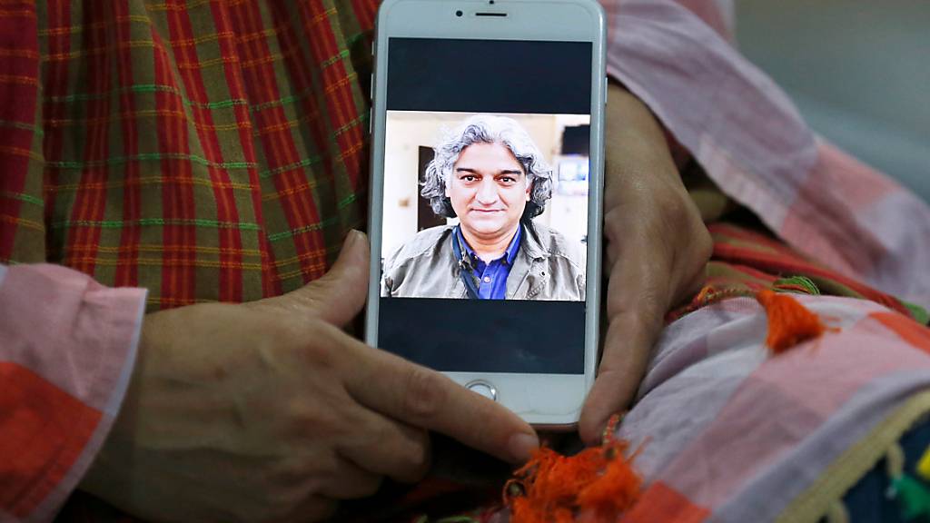 Kaneez Sughra, Ehefrau des verschleppten prominenten pakistanischen Journalisten Matiullah Jan, zeigt Journalisten im Haus eines Verwandten auf einem Smartphone ein Bild ihres Mannes. Der militärkritische Journalist ist nach seiner Verschleppung am Dienstag in der pakistanischen Hauptstadt Islamabad wieder frei. Foto: Anjum Naveed/AP/dpa