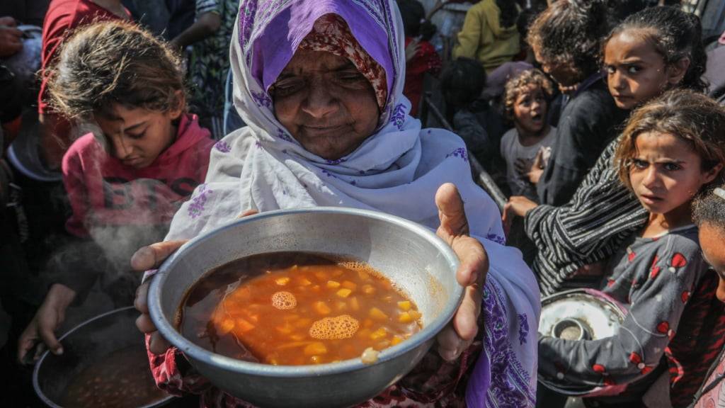 ARCHIV - Palästinenser erhalten Mahlzeiten vom Welternährungsprogramm und dem Hilfswerk der Vereinten Nationen für Palästinaflüchtlinge im Nahen Osten (UNRWA). Die Vereinten Nationen und internationale Organisationen warnen vor einer Hungersnot im Gazastreifen und fordern alle Konfliktparteien, die palästinensischen Gruppierungen und die israelische Regierung auf, die Einfahrt von Hilfslieferungen in den Gazastreifen zu gestatten und ihre Einsätze zu erleichtern, um eine humanitäre Katastrophe im Gazastreifen aufgrund des Konflikts zwischen Israel und der Hamas zu vermeiden. (zu dpa: «Tauziehen um neues Verteilsystem von Hilfsgütern in Gaza») Foto: Abed Rahim Khatib/dpa