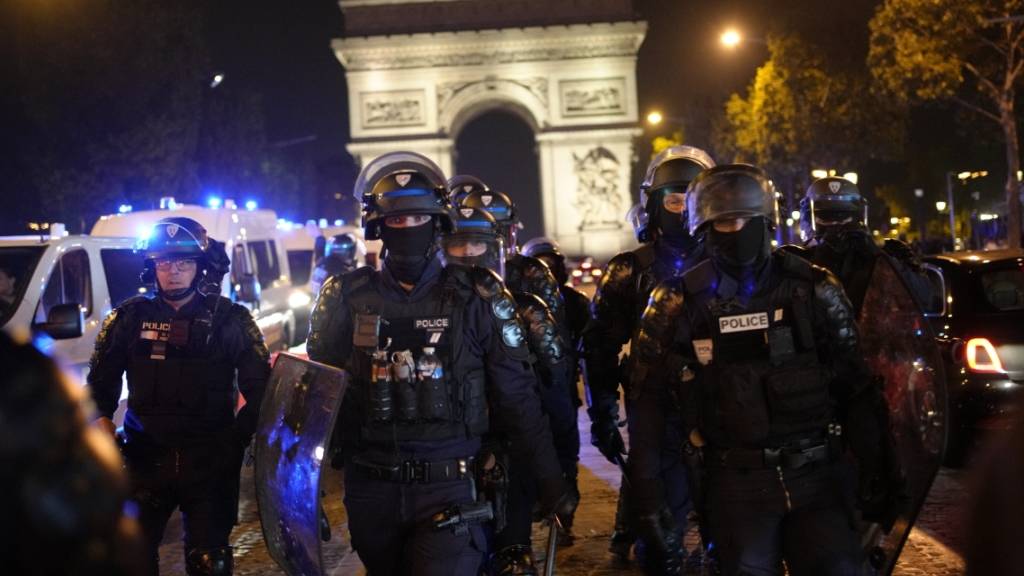 Polizisten patrouillieren vor dem Arc de Triomphe auf der Pariser Champs Élysées. Foto: Christophe Ena/AP