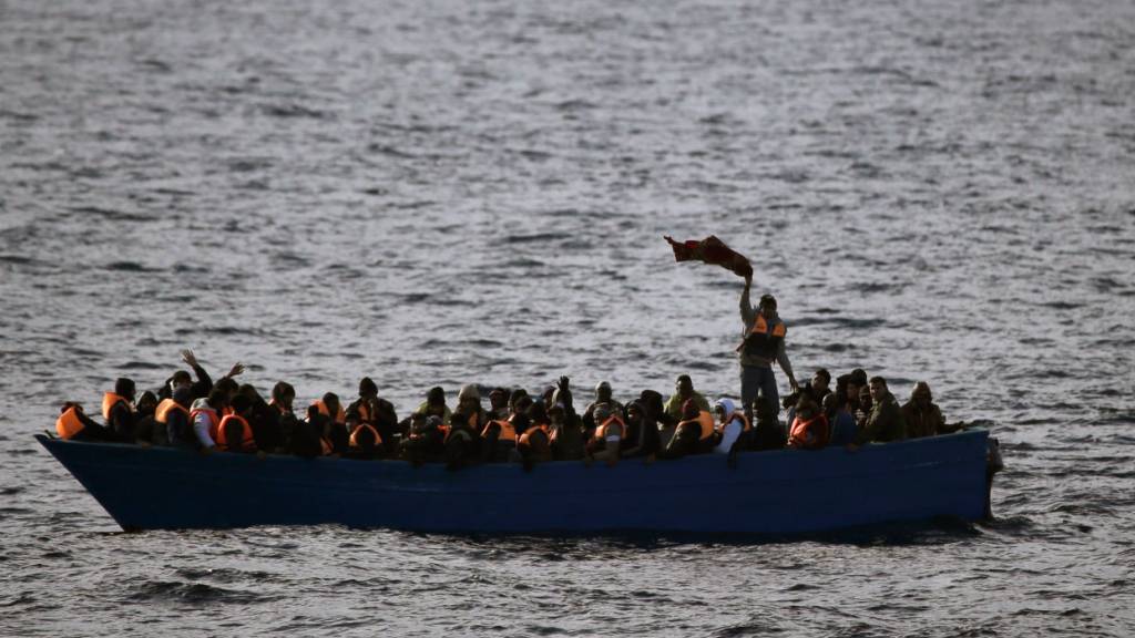 ARCHIV - Flüchtlinge in einem Boot auf dem Mittelmeer. Foto: Emilio Morenatti/AP/dpa/Archivbild