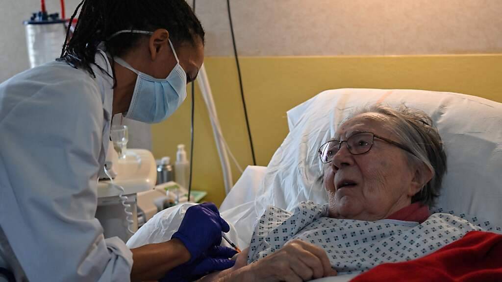 Eine Ärztin verabreicht einer älteren Frau in Frankreich eine Dosis des Corona-Impfstoffs von Pfizer-BioNTech. In der ersten Woche nach dem Impfstart am 27. Dezember gab es in Frankreich Medien zufolge nur einige Hundert Impfungen. Foto: Pascal Guyot/AFP/dpa