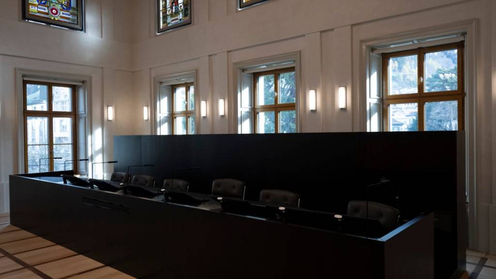 Richterpult im grossen Gerichtssaal des Obergerichts Graubünden an seinem neuen Standort. Am oberen Bildrand sind die wieder eingesetzten, historischen Buntglasfenster zu sehen.