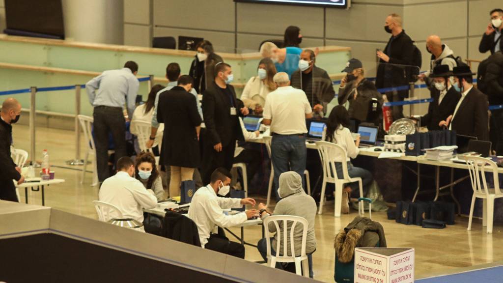 Passagiere des Flugs 232 aus Frankfurt der Fluggesellschaft Arkia Israeli Airlines werden bei der Ankunft am Flughafen Ben Gurion mit elektronischen Armbändern zur Überwachung ausgestattet. Foto: Ilia Yefimovich/dpa