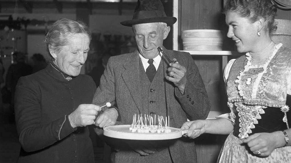 Ein ölteres Appenzeller Paar degustiert den Käse an der 10. Olma 1952 in St. Gallen, aufgenommen im Oktober 1952. (KEYSTONE/Photopress-Archiv/Jules Vogt)