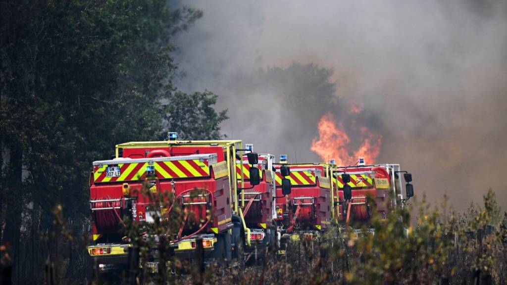 Feuerwehrleute bekämpfen ein Feuer, während in der Nähe von Le Las bei Bordeaux Waldbrände wüten. Foto: Emma Da Silva/AP/dpa