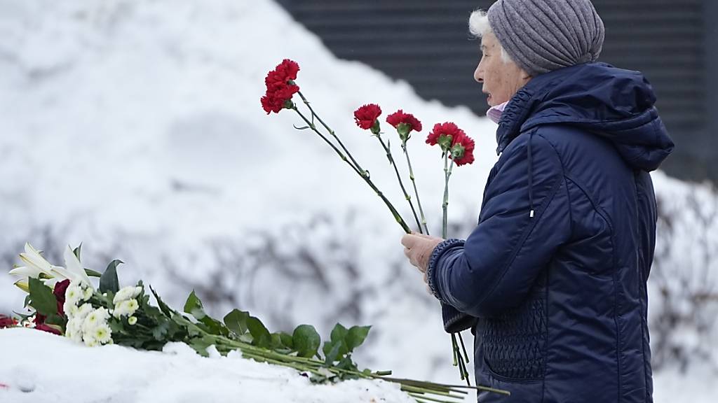 Eine Frau legt Blumen nieder, um Nawalny die letzte Ehre zu erweisen. Foto: Alexander Zemlianichenko/AP/dpa