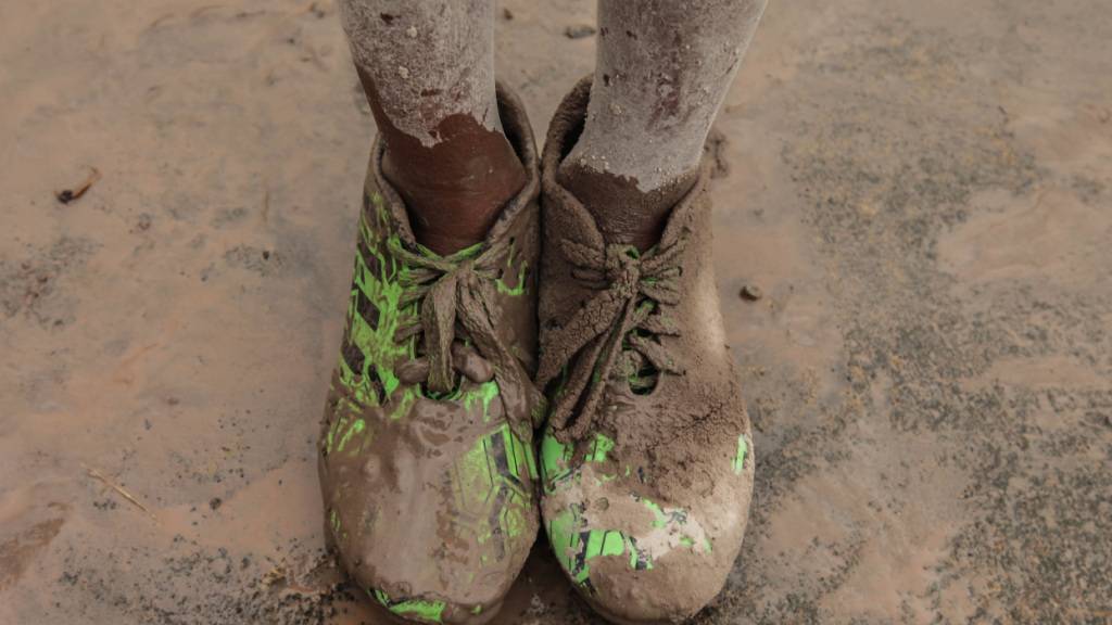 ARCHIV - Mit Vulkanasche verschmutzte Schuhe eines Jungen. Foto: Albert Ivan Damanik/ZUMA Wire/dpa/Archivbild
