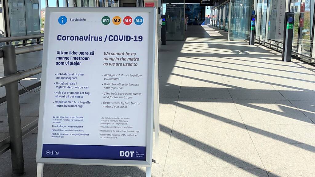 Ein Schild weist an der Metro-Station am Flughafen von Kopenhagen auf die im Nahverkehr geltenden dänischen Maßnahmen zur Eindämmung des Coronavirus hin. Foto: Steffen Trumpf/dpa