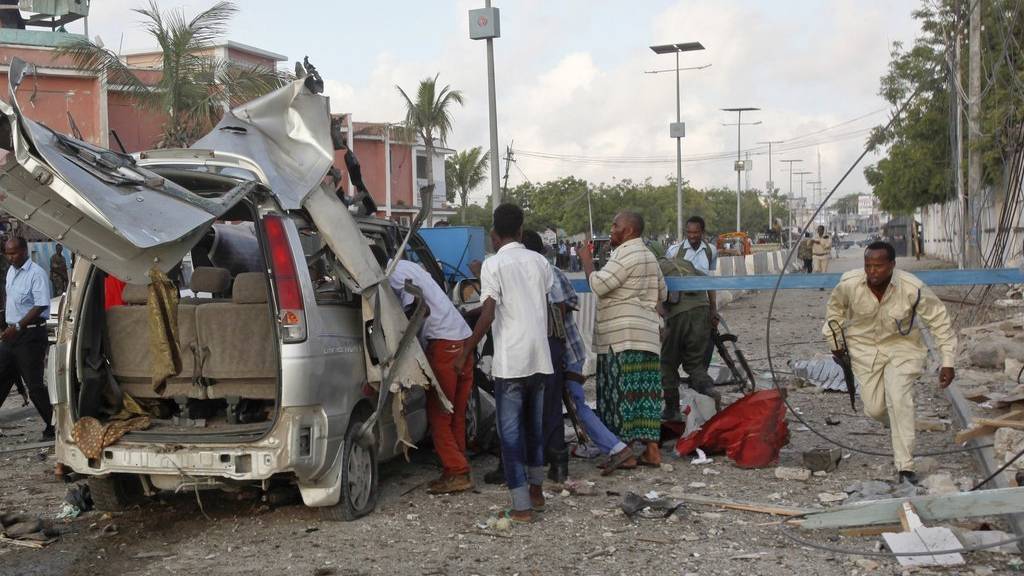 Ein somalischer Polizist kämpft sich durch die Wrackteile beim Sahafi Hotel in Mogadischu. (KEYSTONE/AP Photo/Farah Abdi Warsameh)