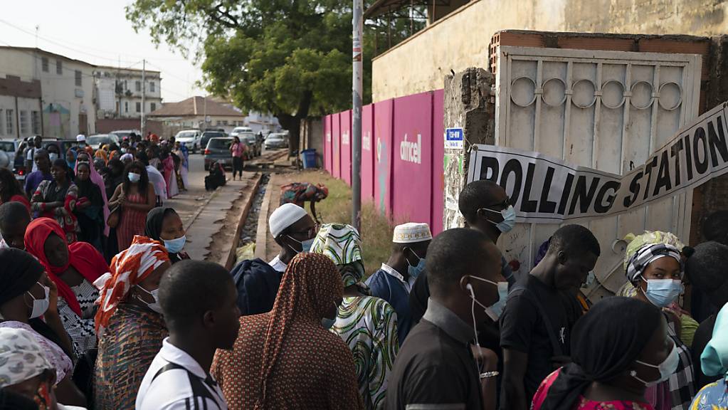 Menschen stehen vor einem Wahllokal in einer Schlange um ihre Stimme für die Parlaments- und Präsidentschaftswahlen abzugeben.
