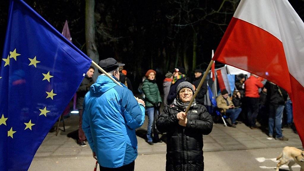 Demonstrierende in Warschau mit den Flaggen Polens und der EU (Archiv)