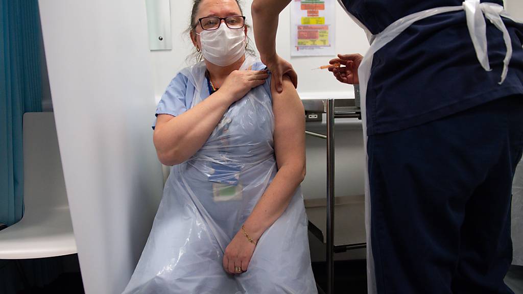 Die Pflegekraft Sue Toye wird im Gesundheitszentrum von Coventry mit dem Impfstoff der Universität Oxford und des Pharmakonzerns AstraZeneca gegen das Coronavirus geimpft. Foto: Jacob King/PA Wire/dpa