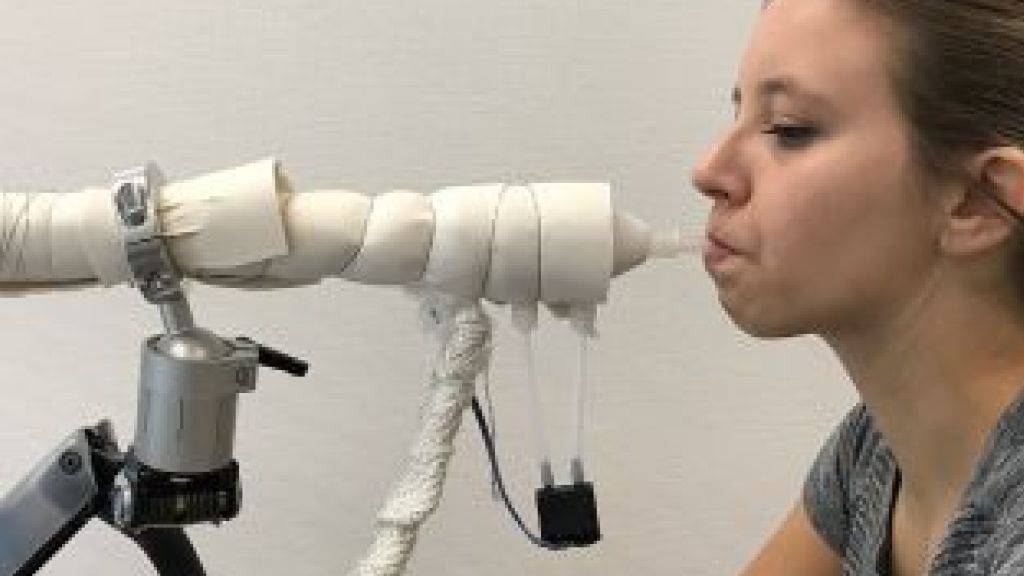 Eine Studentin demonstriert das Gerät, das aufgrund der Atemluft den Fettabbau im Körper nachweist.
