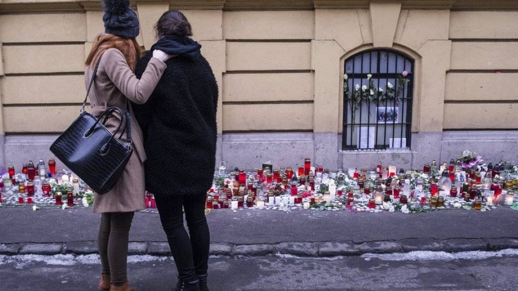Eine Überlebende des Busunglücks und ein anderes Mädchen stehen vor Blumen und Kerzen beim Budapester Gymnasium, wo die meisten der Opfer zur Schule gingen.