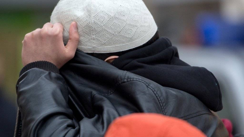 Harmloser Zivilist oder Gefährder? Ein Mann aus dem Umfeld der Koran-Verteilaktion «Lies» verdeckt in Frankfurt am Main mit seiner Jacke sein Gesicht. (Archiv)