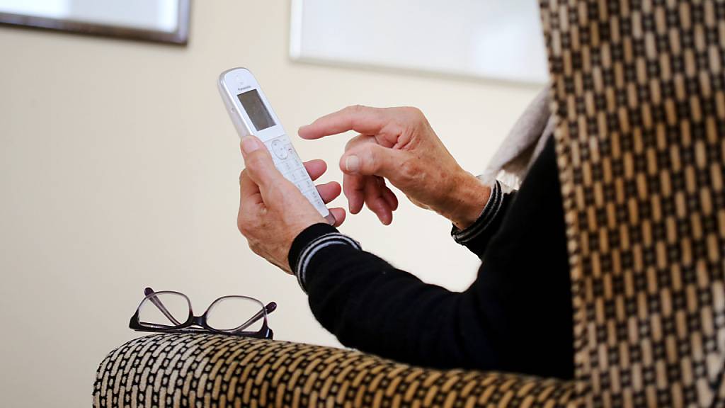 Eine ältere Dame nimmt in ihrer Wohnung ein Telefongespräch an. Gegen unerlaubte Werbeanrufe gehen die Krankeversicherer nun vor. (Archivbild)