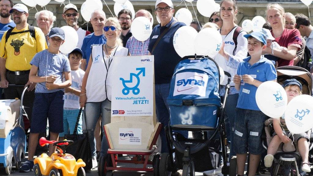 Aktivisten werben mit Kinderwagen und Ballonen für die Volksinitiative für einen vierwöchigen Vaterschaftsurlaub. (Archivbild)