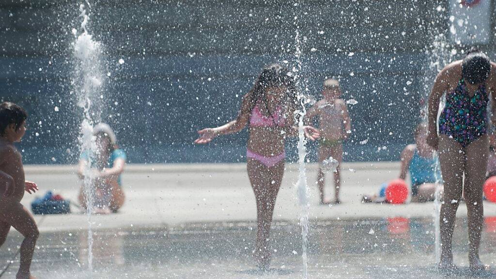 Kinder vergnügen sich beim Wasserspiel auf dem Bundesplatz. (Archivfoto).